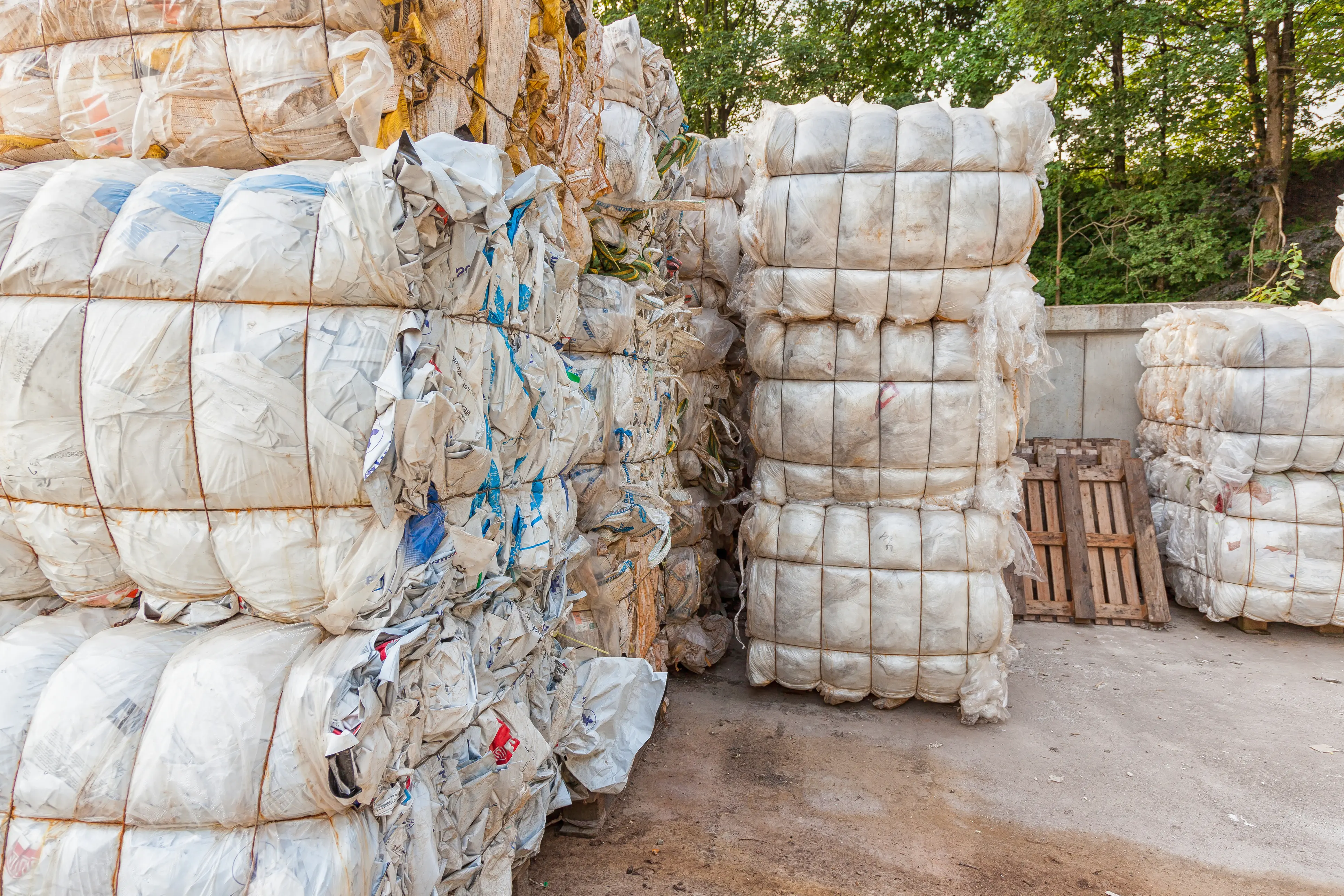 Bales of compressed plastic waste stacked for recycling