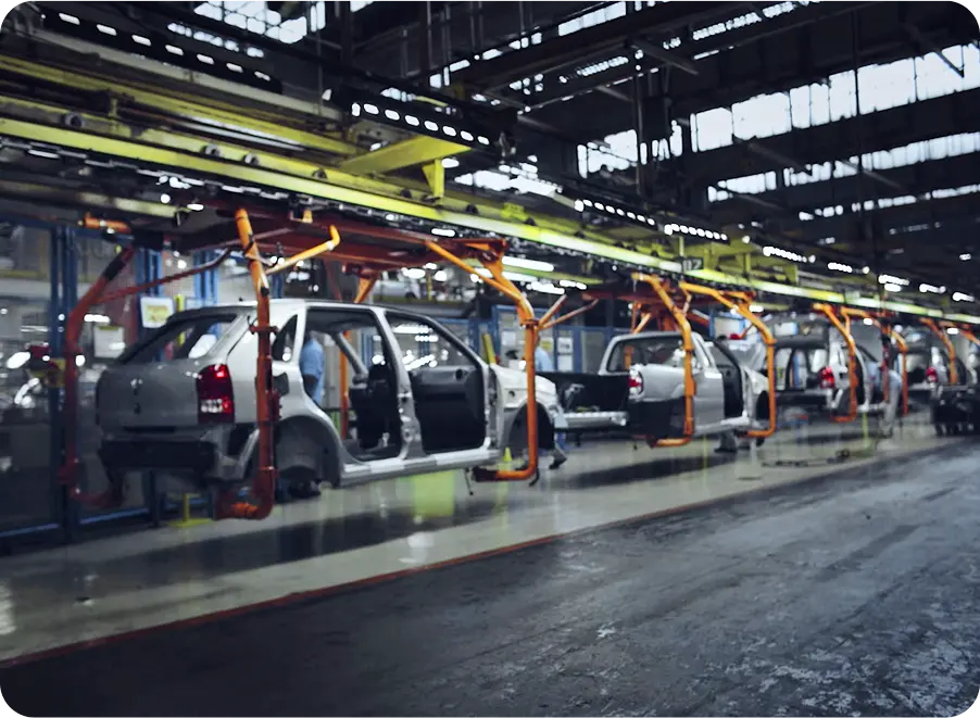 Still of inside of car manufaturers, showing cars on conveyor belt in production line